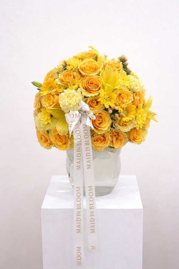 Bouquet of yellow flowers with a visible brand name on a white background
